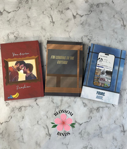 Three books on a marble surface with 'Blossom Binds' branding.