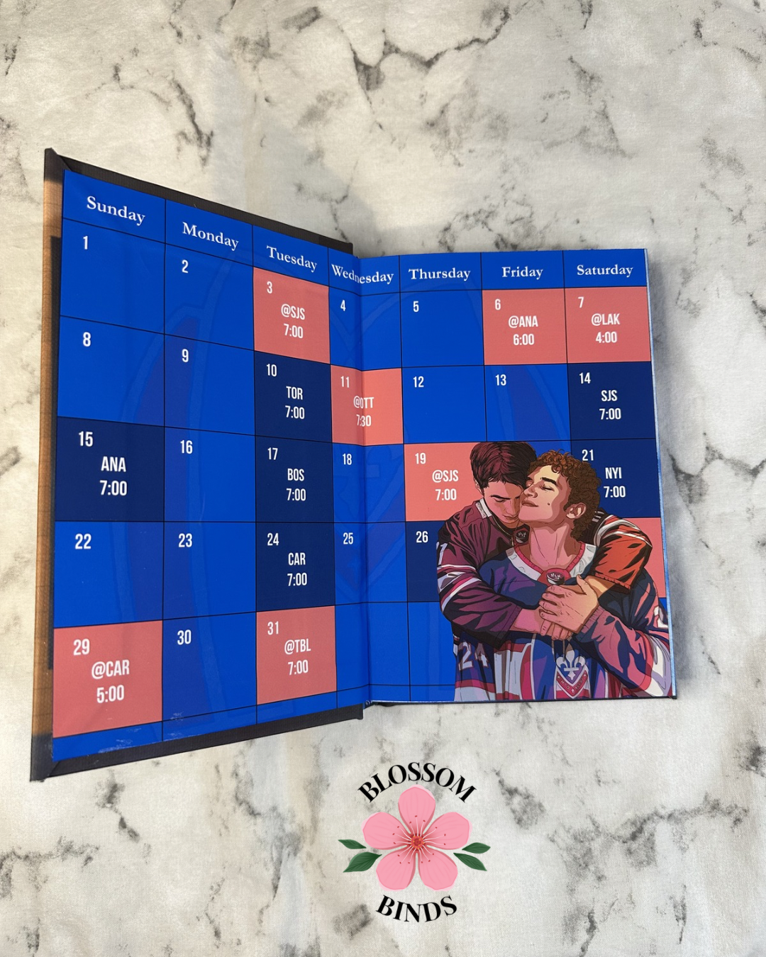Foldable calendar with a couple on it, displayed on a marble surface with 'Blossom Binds' branding.