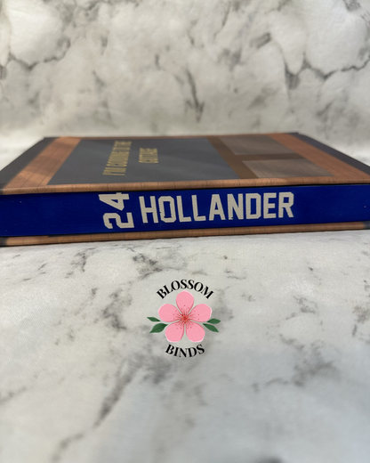 Book with '24 Hollander' with a visible brand logo on a marble background